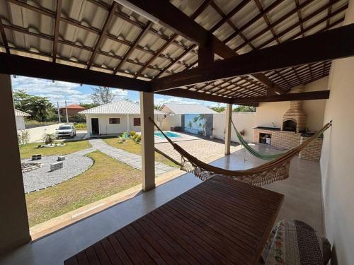 a hammock in a house with a view of a yard at Casa Praia seca!100 Metros Da Praia!Com Piscina! in Araruama