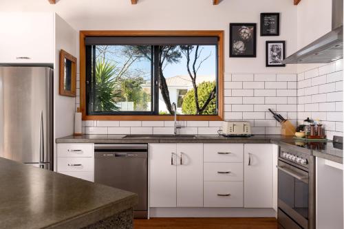 a kitchen with white cabinets and a window at A Room With a View in Kaikoura