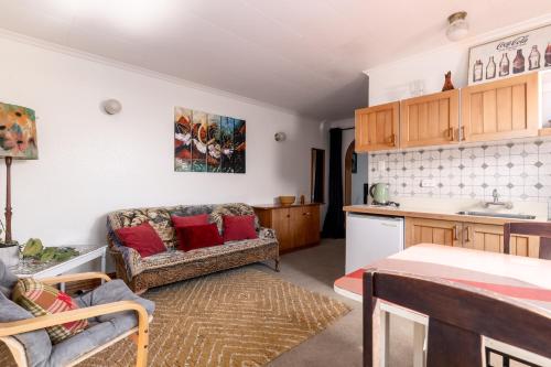 a living room with a couch and a kitchen at A Room With a View in Kaikoura