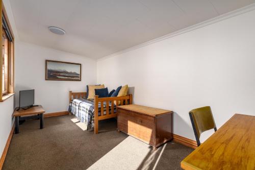 a bedroom with a bed and a desk and a table at A Room With a View in Kaikoura