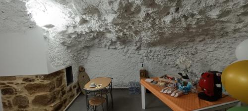 a room with a table and a stone wall at All inBasilicata Bed & Breakfast in Baragiano