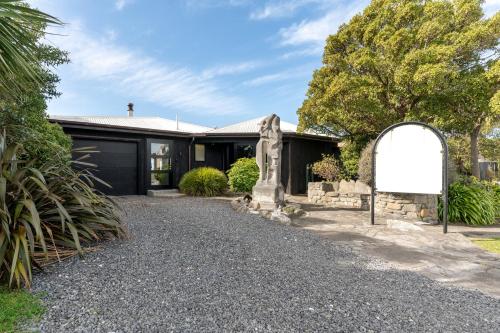 a home with a sign in front of a driveway at A Room With a View in Kaikoura