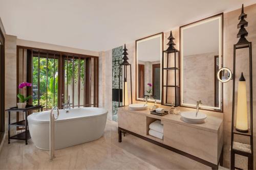 a bathroom with two sinks and a bath tub at The St. Regis Bali Resort in Nusa Dua