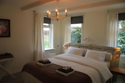 een slaapkamer met een groot bed en 2 handdoeken bij B&B Droom 44 in Buinerveen