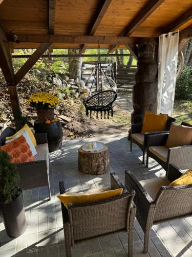 a patio with chairs and tables under a wooden roof at Emerald Chalet in Praid