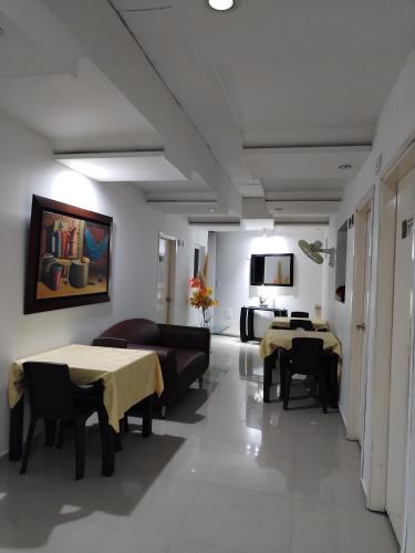 a living room with two tables and a couch at Hotel La Leyenda Vallenata in Valledupar