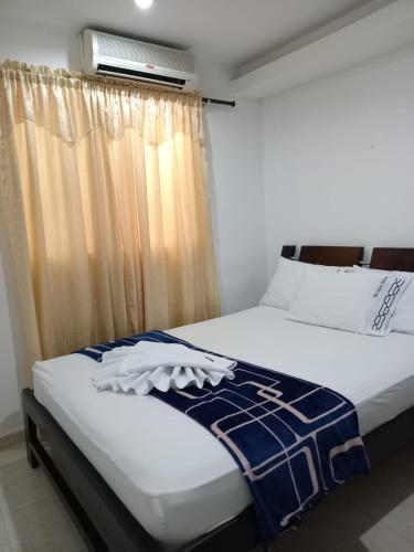 a bedroom with a bed and a window with at Hotel La Leyenda Vallenata in Valledupar