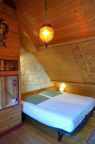 une chambre avec un lit dans une pièce en bois dans l'établissement Maison au calme dans village fleuri - Jardin clos, à Locmaria