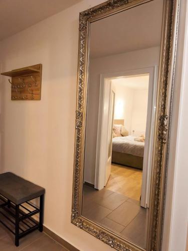 a mirror on a wall in a room with a bed at Falk Homes- Luxus Apartments, ideal für Geschäftsreisende & Familien - nahe Messe, im Zentrum Nürnbergs mit Balkon, Arbeitsplatz & Parkplatz, Handtücher & Bettwäsche, nähe Playmobilfunpark, self check-in in Nürnberg