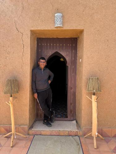 a man standing in a door of a building at berber desert home for rent in Merzouga