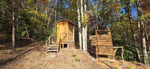 a wooden out house in the middle of a forest at Charming enclave Luxury tent in the woods Tent 3 Bambi's playground in Lenoir