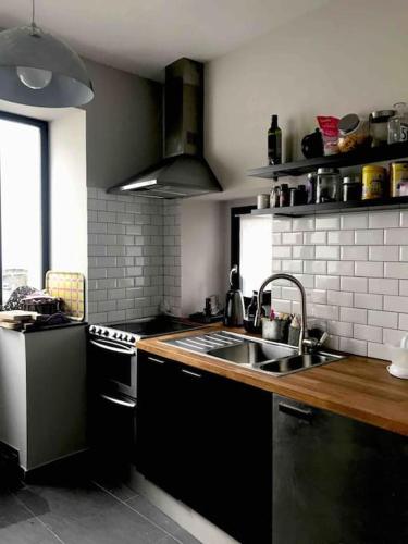 une cuisine avec un évier et une cuisinière dans l'établissement Maison pecheur dans le banzeau, à Noirmoutier-en-l'lle