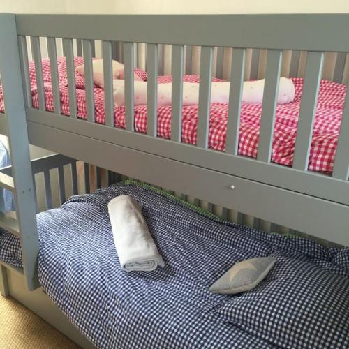 - un lit bébé avec une couverture bleue et blanche et un oreiller dans l'établissement Maison pecheur dans le banzeau, à Noirmoutier-en-l'lle