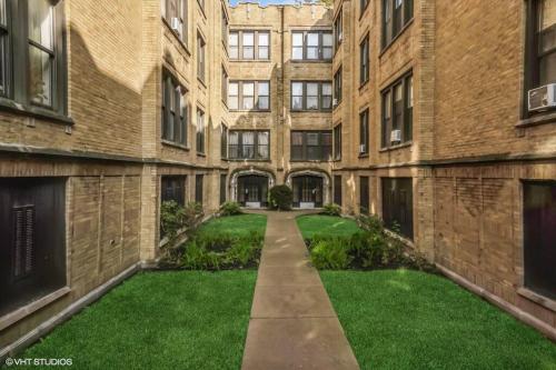 an empty courtyard of an apartment building with grass at 2 BR Apt Near U Chicago Campus & the Lakefront! in Chicago