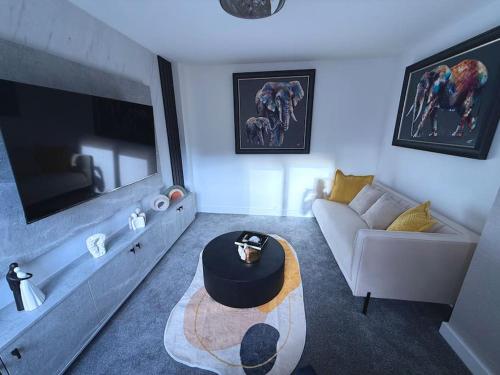 a living room with a couch and a table at Adeluxe Home - Luxury 2 Bedroom Entire House with Free WiFi, Disney, Netflix and Amazon Prime Included in Burton upon Trent