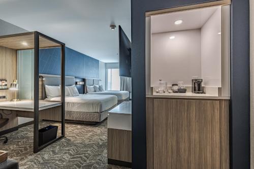 a hotel room with a bed and a bathroom at SpringHill Suites by Marriott Fort Wayne Southwest in Fort Wayne