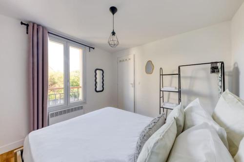 une chambre blanche avec un lit et une fenêtre dans l'établissement T2 Proche de Paris Métro 5, à Pantin