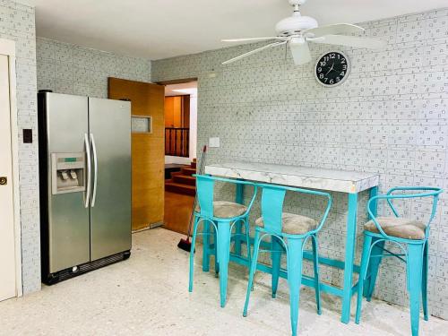 a kitchen with a blue table and chairs and a refrigerator at Luna Llena in Monterrey