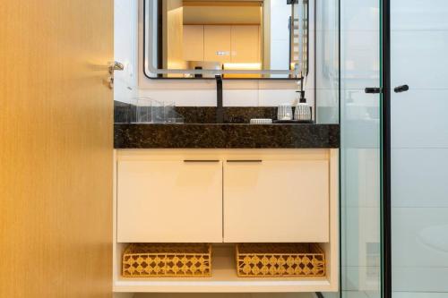 a bathroom with a sink and a mirror at Brasília a 400m do metrô in Brasilia