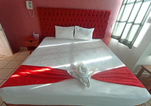 a bedroom with a large bed with a red headboard at Hotel La Intimidad in Antón Lizardo