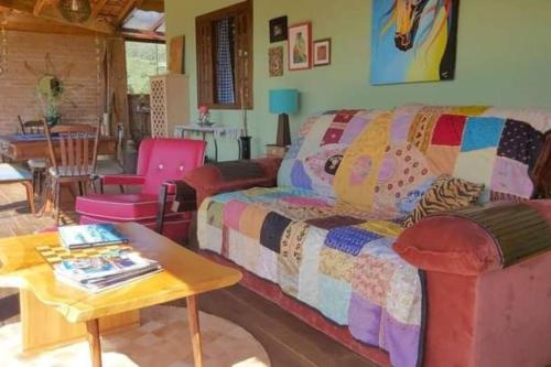 a living room with a couch and a table at Charmosa Cabana Passarim, Gonçalves, Costas in Paraisópolis