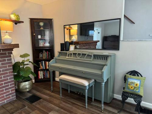 a green piano in a living room with a mirror at Spacious Relaxing Baltimore Home with Hot Tub in Baltimore