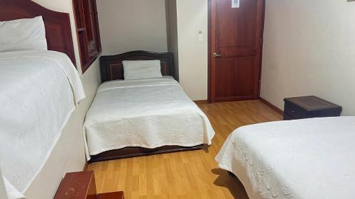 a small bedroom with two beds and a small closet at Internacional El Nogal Ipiales in Ipiales