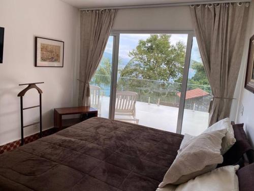 a bedroom with a large bed and a large window at Mansão Panorâmica Angra dos Reis in Angra dos Reis