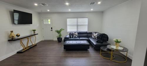 a living room with a black couch and a tv at Beautiful modern house in Clearwater