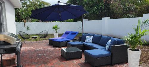 a patio with blue furniture and an umbrella at Beautiful modern house in Clearwater