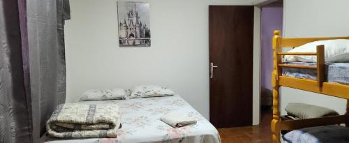 a bedroom with a bed and a bunk bed at Pousada Catarina - 2 in Maringá