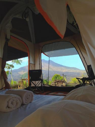 een tent met uitzicht op de bergen van binnenuit bij ' Kintamani Adventures' Nature,'s back drop, picnic delight ' in Kintamani