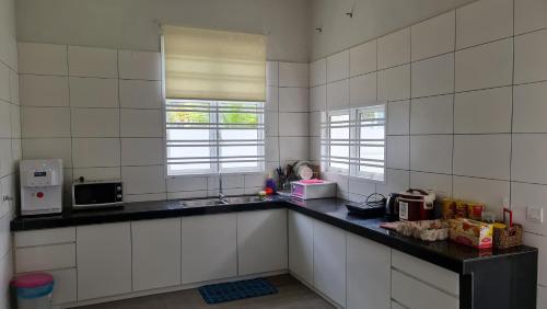 a kitchen with white tiled walls and a counter top at Selendang In Krubong Near Std Hang Jebat, MITC & UTEM in Melaka