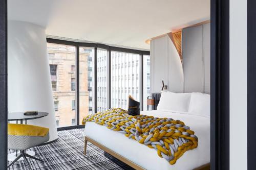 a hotel room with a bed and a large window at W Melbourne in Melbourne