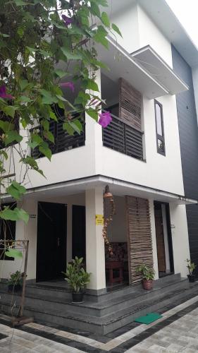 a white house with stairs and a balcony at Varkala Days Home Stay in Varkala