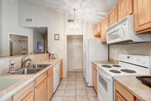 a kitchen with white appliances and wooden cabinets at Seashell Memories in Rockport