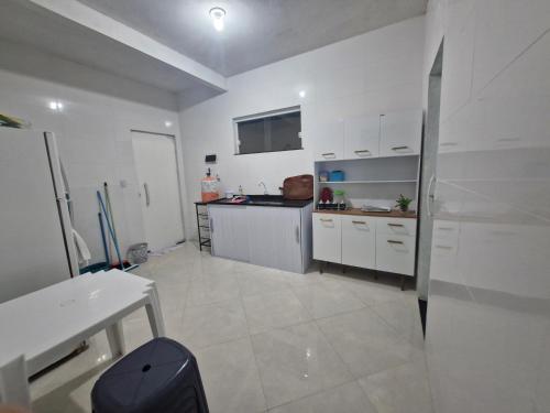 a kitchen with white cabinets and a counter top at Casa do Pepe em Barra de Jacuípe in Camaçari