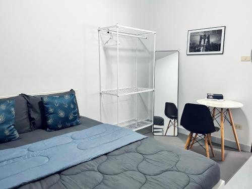 a bedroom with a bed and a table and a desk at The Chill Town Home in Maha Sarakham