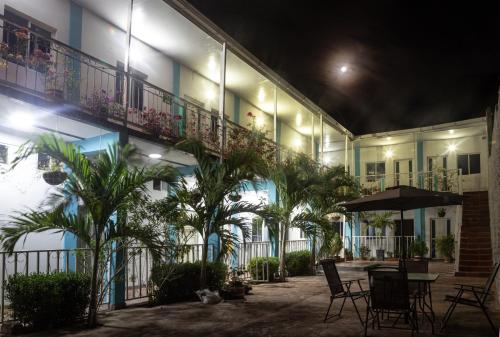 a courtyard of a building with a table and palm trees at Palaa Mujuii Hotel in Dibulla