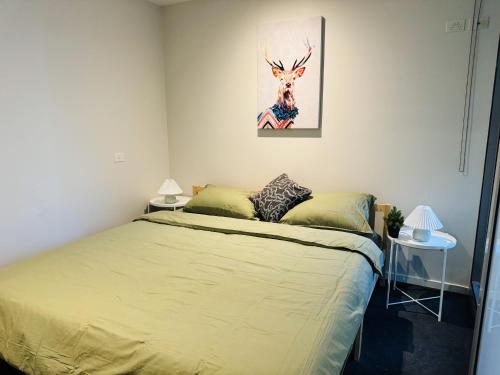 a bedroom with a bed and a painting on the wall at Minimalist 2-Bed, 2-Bath Apartment in Melbourne CBD - Free Parking in Melbourne