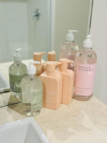 a group of four bottles of soap on a counter at Minimalist 2-Bed, 2-Bath Apartment in Melbourne CBD - Free Parking in Melbourne