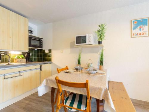 une petite cuisine avec une table et des chaises dans une pièce dans l'établissement Studio 4 pers, proche commerces et téléphérique, balcon et navette gratuite - FR-1-296-506, à Saint-Lary-Soulan