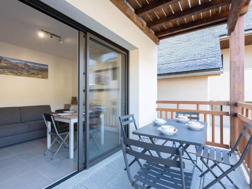un patio avec une table et des chaises sur un balcon dans l'établissement À Loudenvielle, T2 moderne, proche télécabine, parking, wifi - FR-1-695-61, à Loudenvielle