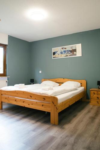 a large wooden bed in a room with blue walls at Between Lakes Apartments - 58 in Interlaken