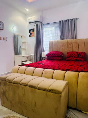a bedroom with a large bed with red pillows at Vokzluxuryshortlet 1-Bedroom Apartment in Port Harcourt