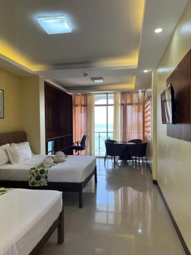 a hotel room with two beds and a dining room at C View Resort in Sipalay