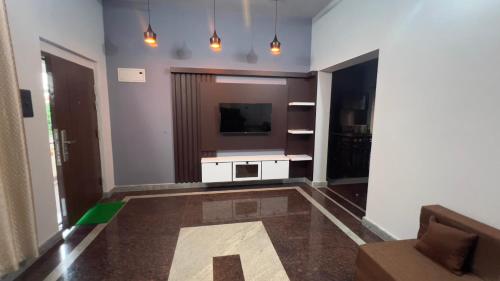 a living room with a television and a couch at Peaceful Getaway in Udupi Manipal in Udupi