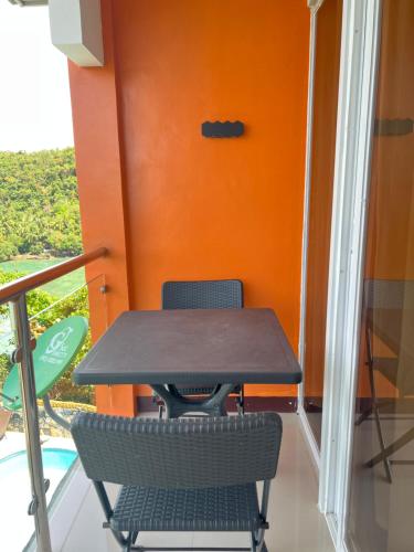 a table and chairs on a balcony with an orange wall at C View Resort in Sipalay