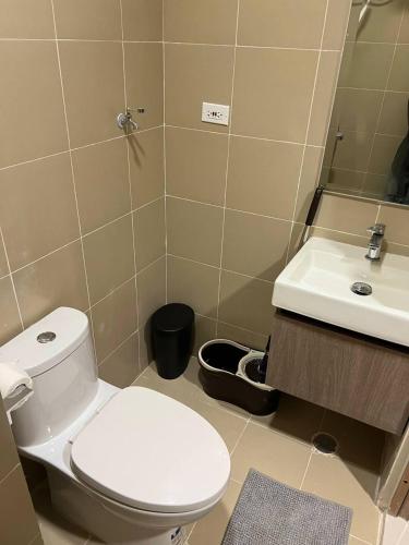 a bathroom with a toilet and a sink at Modern City Escape Near MOA and Airport with Balcony and Fast WiFi in Manila