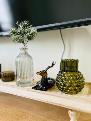 a shelf with a vase and a figurine on it at Modern City Escape Near MOA and Airport with Balcony and Fast WiFi in Manila